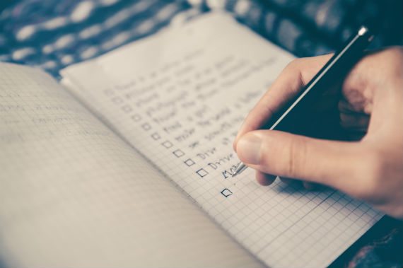 get motivated person writing a checklist in notebook