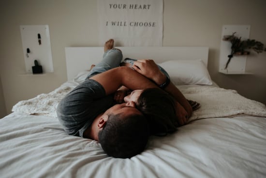a couple embracing in bed
